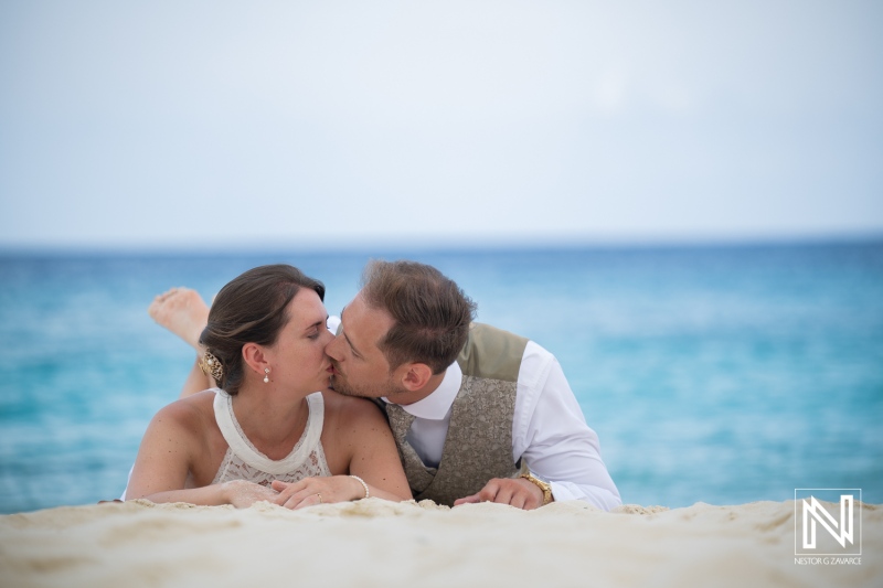 Couple kisses during a Trash the Dress session at Cas Abao Beach in Curacao under the bright sky and near clear waters