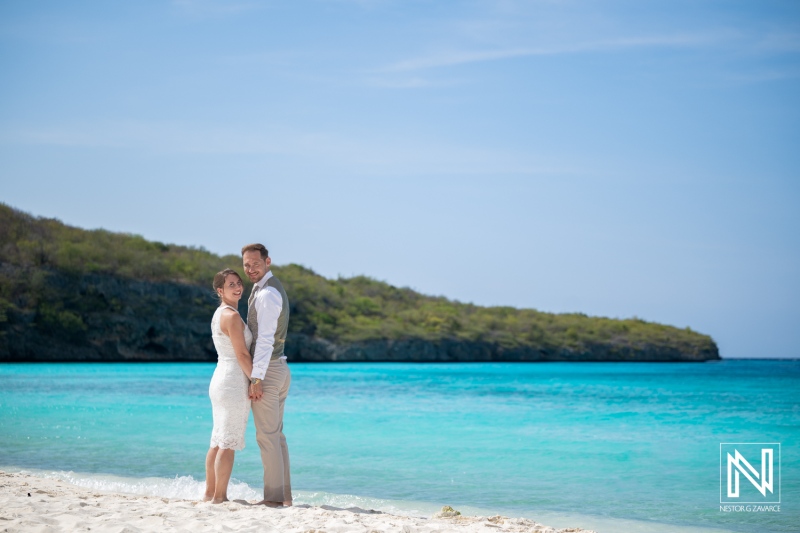 Couple poses on the beach during Trash the Dress session at Cas Abao Beach in Curacao in bright sunlight