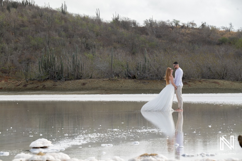 Couple participates in trash the dress session at a salt flat in Curacao during a sunny day