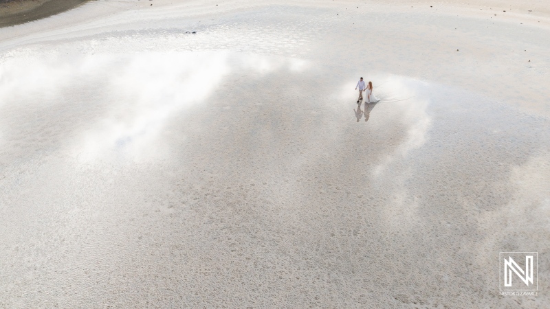 Couple enjoys trash the dress session on the beach in Curacao with reflections in the water