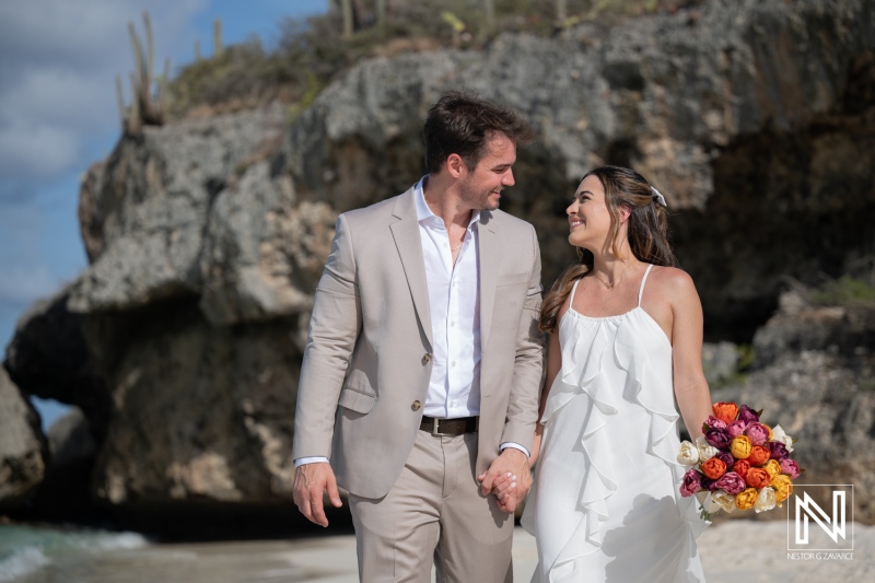 Couple participates in a trash the dress session at Cas Abao Beach in Curacao during a sunny day