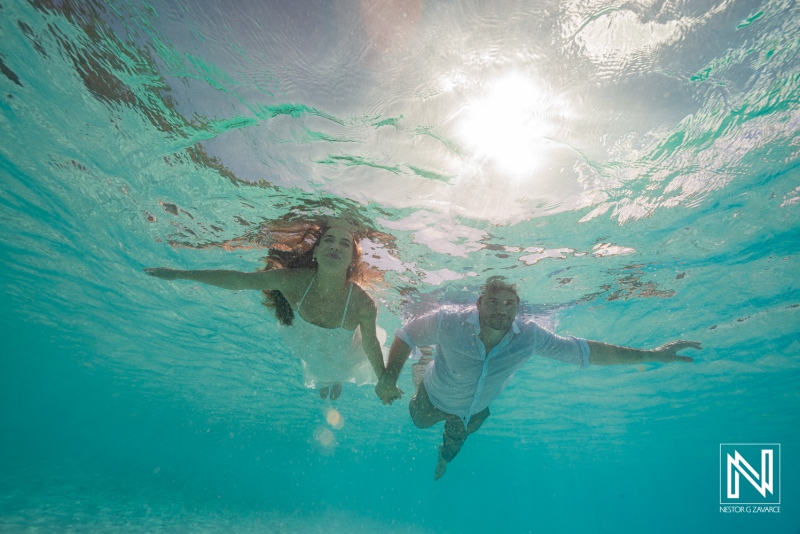 Couple enjoys trash the dress session while swimming at Cas Abao Beach in Curacao under the sun