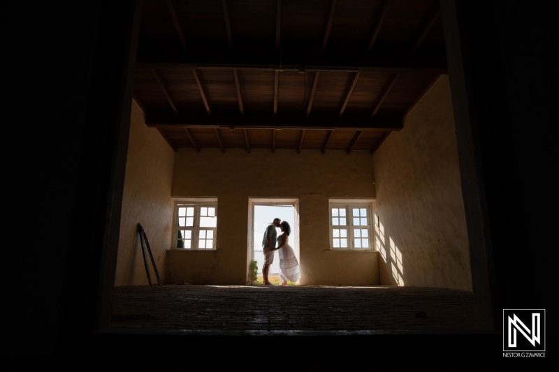 Couple shares an intimate moment in a rustic setting at Cas Abao, Curacao after a Trash the Dress session