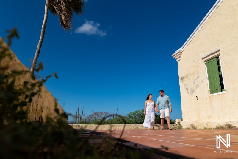 Couple walks hand in hand on a sunny day at Cas Abao, Curacao during a trash the dress session