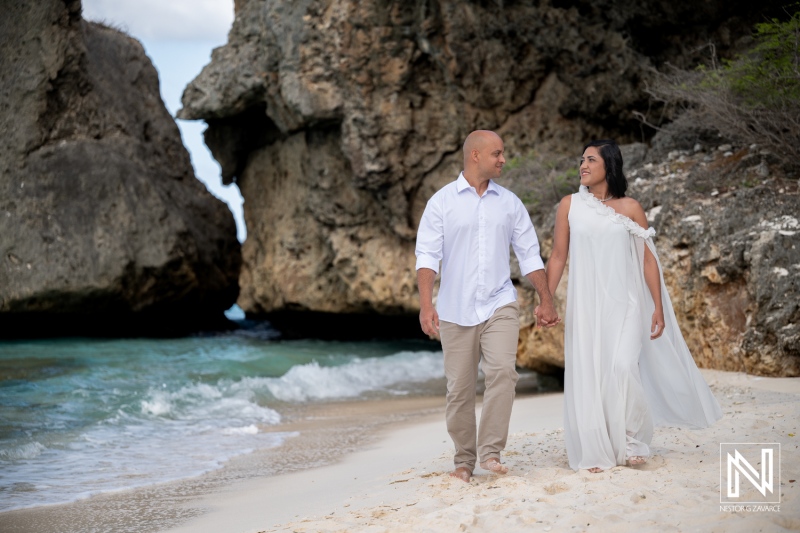 Couple walks hand in hand during trash the dress session at Cas Abao Beach in Curacao