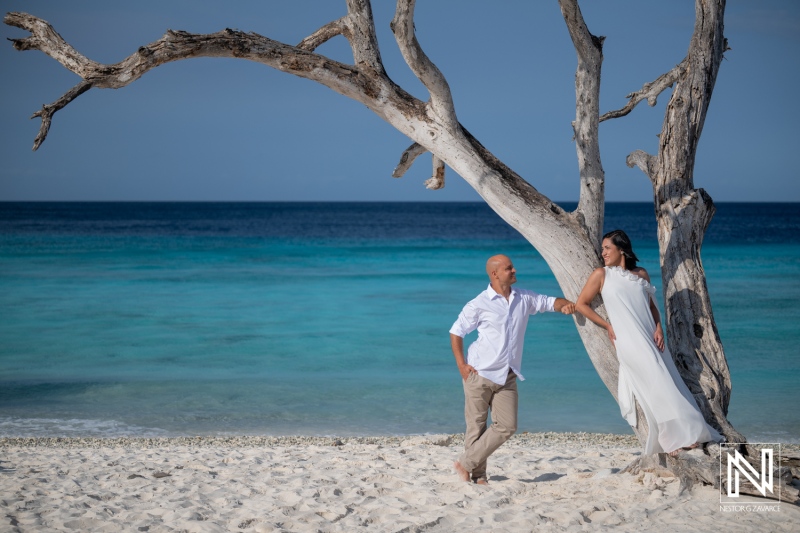 Couple enjoys trash the dress session at Cas Abao Beach in Curacao with blue water and trees