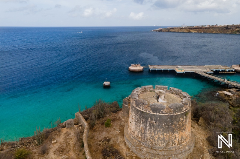 Aerial View of an Ancient Coastal Fort and Harbor at Sunset, Showcasing the Turquoise Waters and Rugged Landscape of a Mediterranean Island