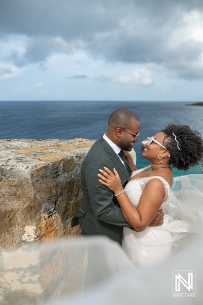 A Joyful Couple Shares a Romantic Moment on a Cliff Overlooking the Ocean During Their Wedding Ceremony at a Picturesque Outdoor Venue in Sunny Weather