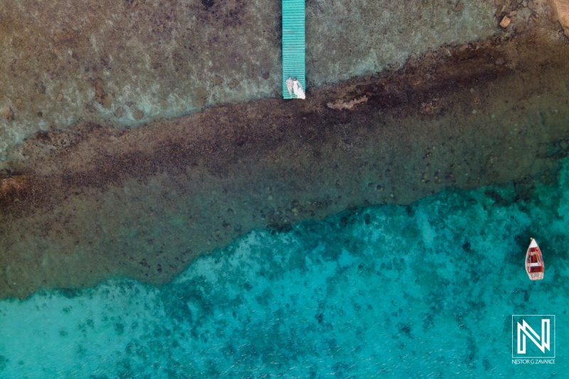 Couple enjoying a romantic trash the dress session at Boka Sami in Curacao with vibrant blue waters and serene surroundings