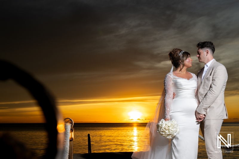 Couple embraces romantic sunset at Kokomo Beach during Trash the Dress session in Curacao, showcasing love and beauty in a stunning beach setting