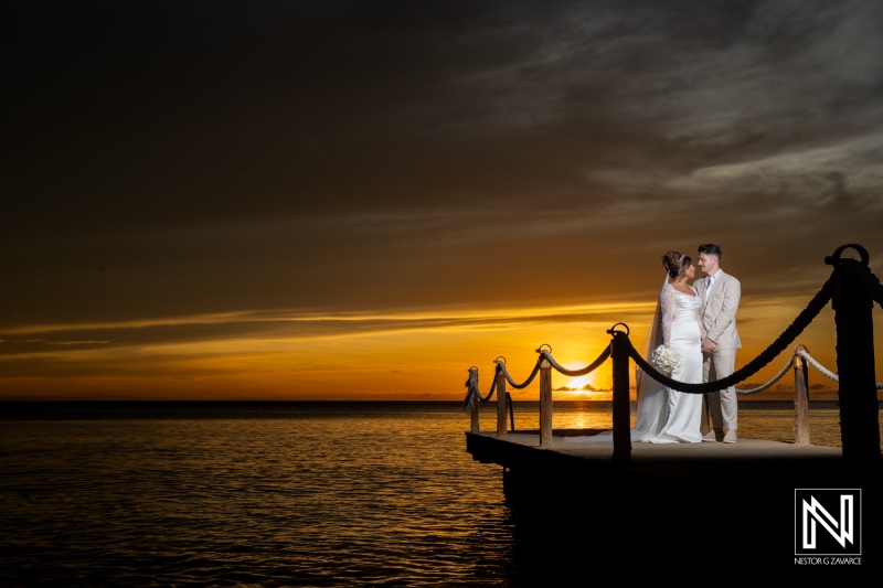 Couple embraces during Trash the Dress session at Kokomo Beach in Curacao as sun sets on a beautiful evening