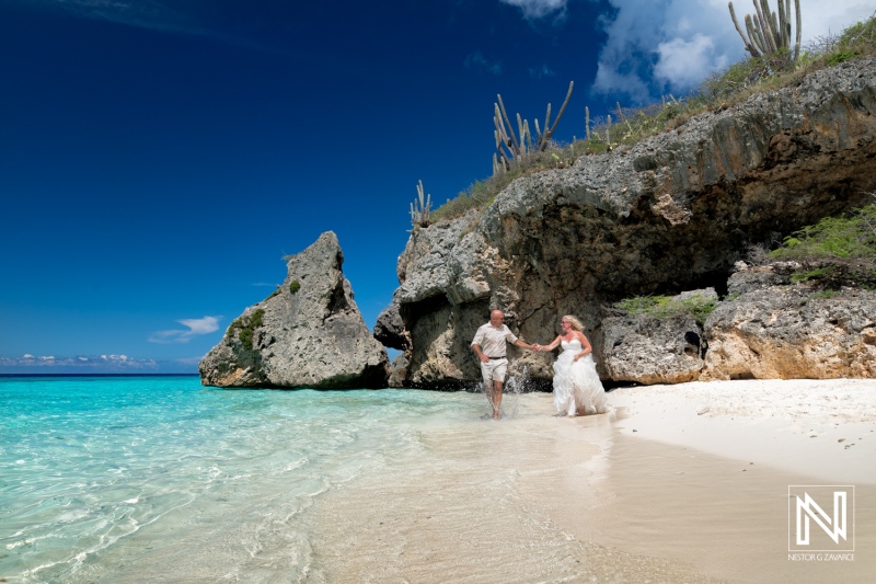 Couple enjoying a romantic moment on Cas Abao Beach in Curacao during a Trash the Dress session under a bright blue sky