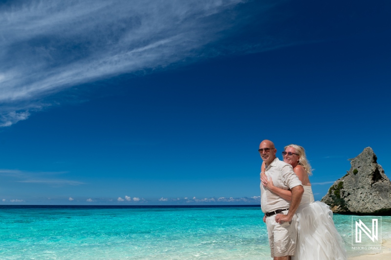 Couple celebrating love at Cas Abao Beach in Curacao during a Trash the Dress session with stunning turquoise waters and beautiful skies