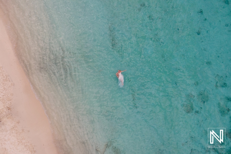 Couple enjoys romantic trash the dress session in clear waters at Cas Abao Beach in Curacao during sunset