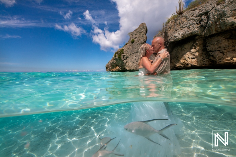 Couple enjoys unique trash the dress session in turquoise waters of Cas Abao Beach, Curacao, showcasing love and adventure