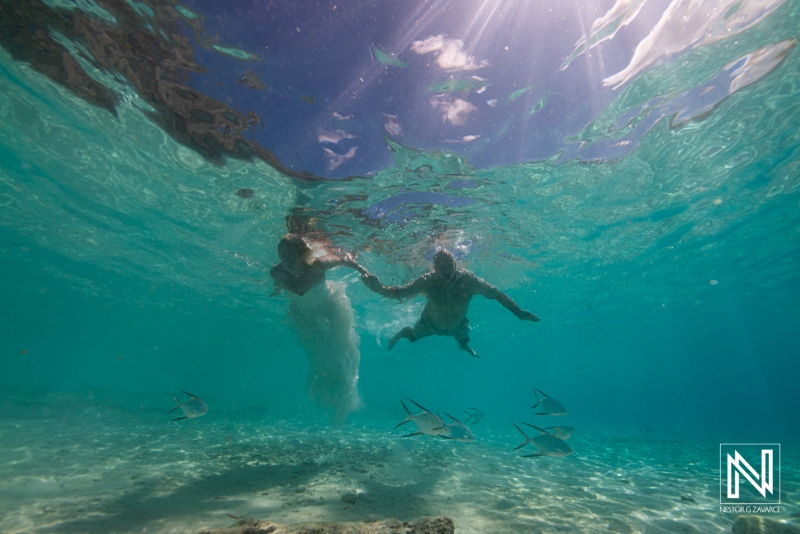 Couple enjoys a memorable Trash the Dress session in the crystal-clear waters of Cas Abao Beach, Curacao, under the warm tropical sun