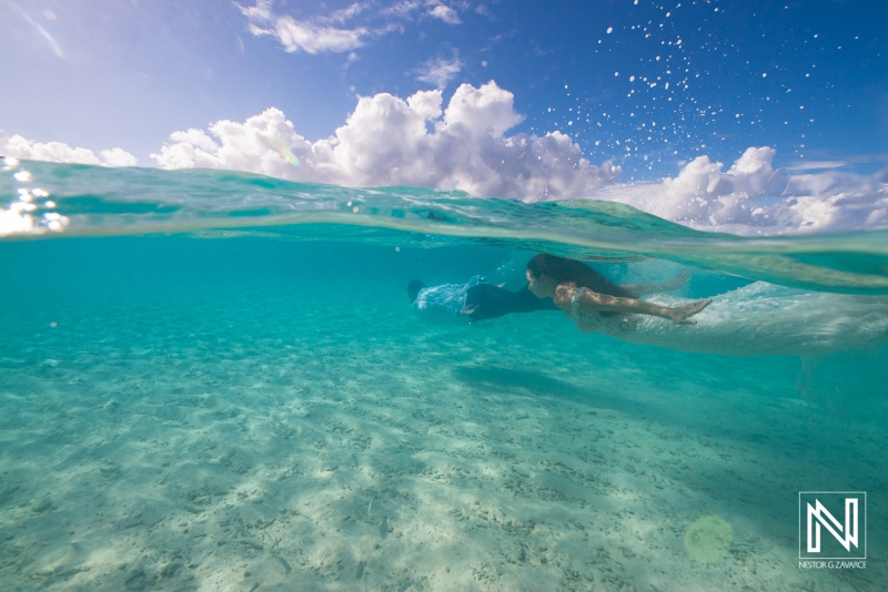 Couple enjoys an adventurous trash the dress session in the clear waters of Curacao on a sunny day