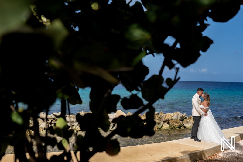 Captured love in Curacao during a trash the dress post-wedding photoshoot by the serene turquoise waters