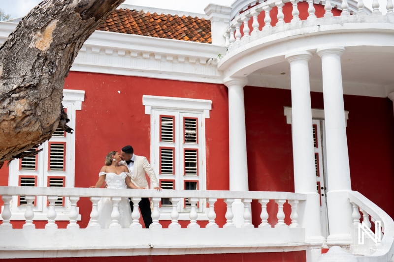 Enjoying a romantic moment during a post-wedding trash the dress session in Curacao against a vibrant backdrop