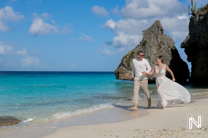 A Joyful Couple Runs Along a Tropical Beach Under a Clear Blue Sky, Enjoying Their Wedding Day at a Picturesque Seaside Location