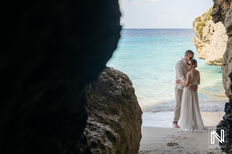 Couple Embracing on a Secluded Beach Surrounded by Cliffs During a Sunny Day, Capturing a Moment of Love and Tranquility