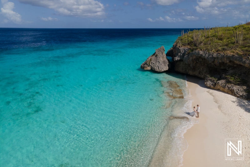 A Couple Enjoying a Serene Moment Together on a Secluded Beach With Turquoise Waters and Softly Rolling Waves Under a Clear Sky