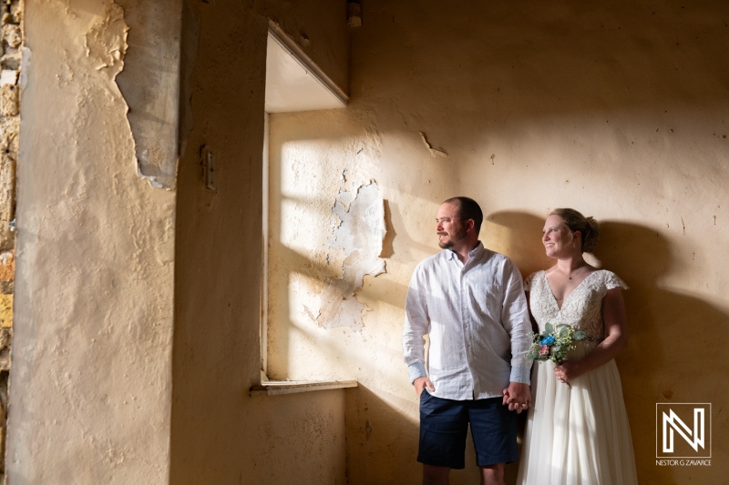 Couple enjoys intimate moment during Trash the Dress session at Cas Abao Beach in Curacao under soft sunlight