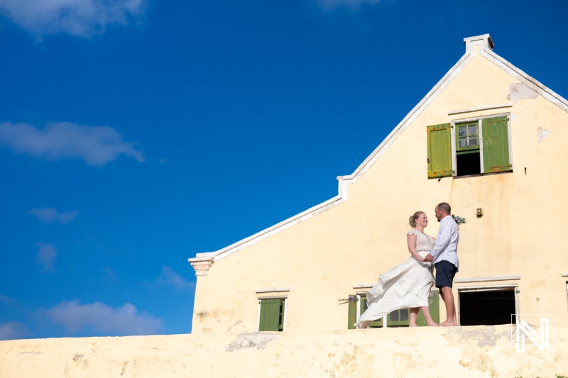 Romantic trash the dress session at Cas Abao Beach, Curacao, featuring a happy couple enjoying their special moment with a bright blue sky