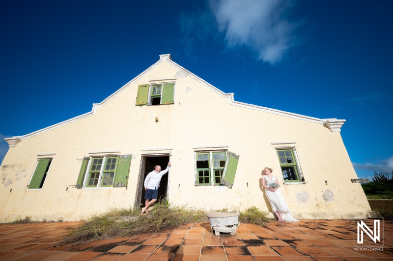 Romantic Trash the Dress session at Cas Abao Beach in Curacao capturing joyful moments by the historic architecture