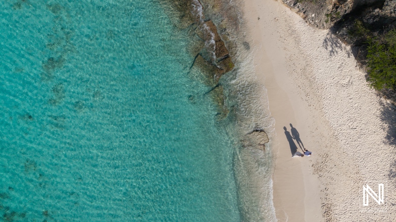 Couple enjoying a romantic moment during a Trash the Dress session at Cas Abao Beach in Curacao with clear blue waters and sandy shoreline