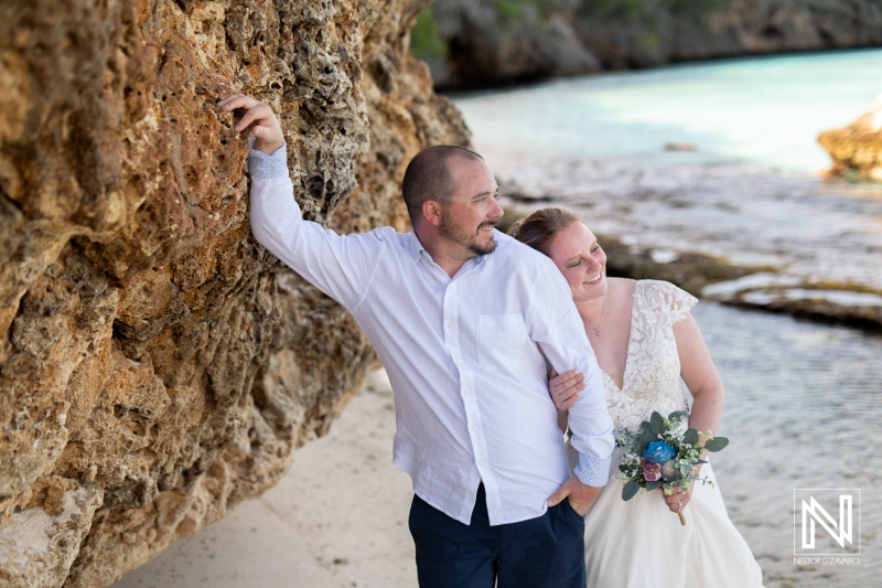 Couple celebrates love at Cas Abao Beach in Curacao during a Trash the Dress session, capturing joyful moments by the stunning shoreline
