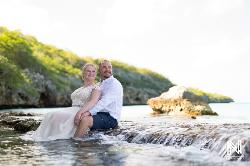 Couple celebrates love during Trash the Dress session at Cas Abao Beach in Curacao, capturing joyful moments in the serene water