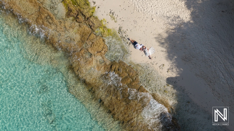 Beautiful couple enjoys a romantic moment on Cas Abao Beach in Curacao during a Trash the Dress session at sunset
