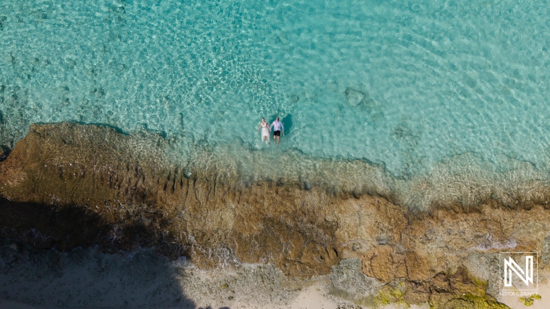 Couple embraces romance during Trash the Dress session at Cas Abao Beach in Curacao's stunning turquoise waters