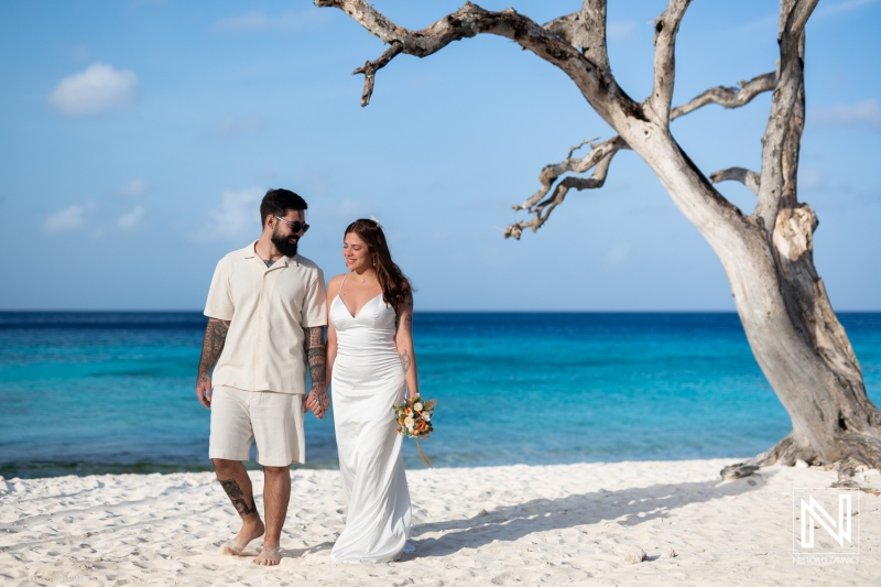 Couple enjoying a romantic walk on Cas Abao Beach in Curacao while celebrating their trash the dress moment in a stunning wedding gown