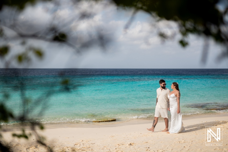 Couple enjoys a romantic stroll on Cas Abao Beach in Curacao during a Trash the Dress session surrounded by stunning turquoise waters and soft sands