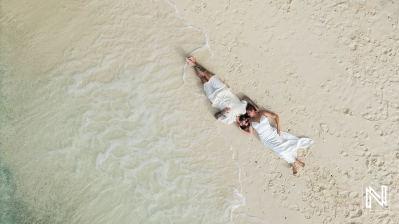 Couple enjoying a romantic moment on Cas Abao Beach in Curacao while trashing the dress during a sunset photo shoot