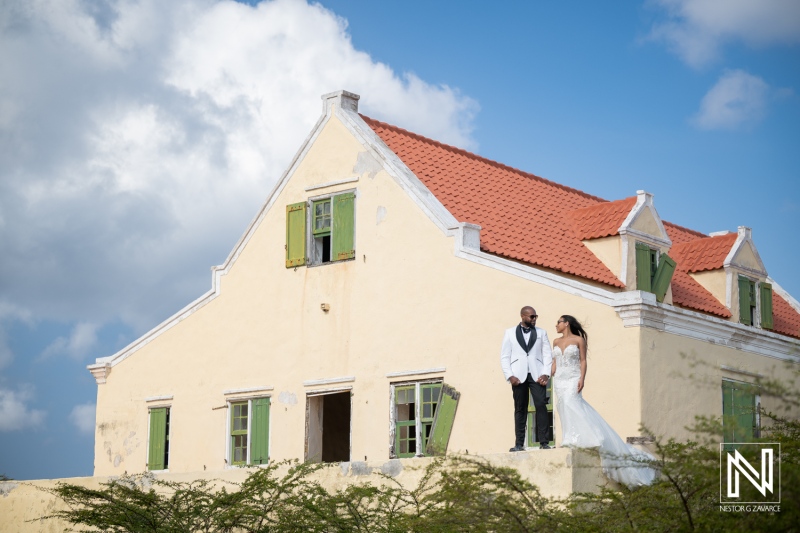 Trash the dress photoshoot in Curacao with couple standing on building rooftop