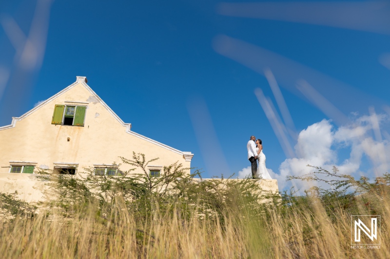 Trash the dress photoshoot in Curacao with couple near historic building in sunny weather