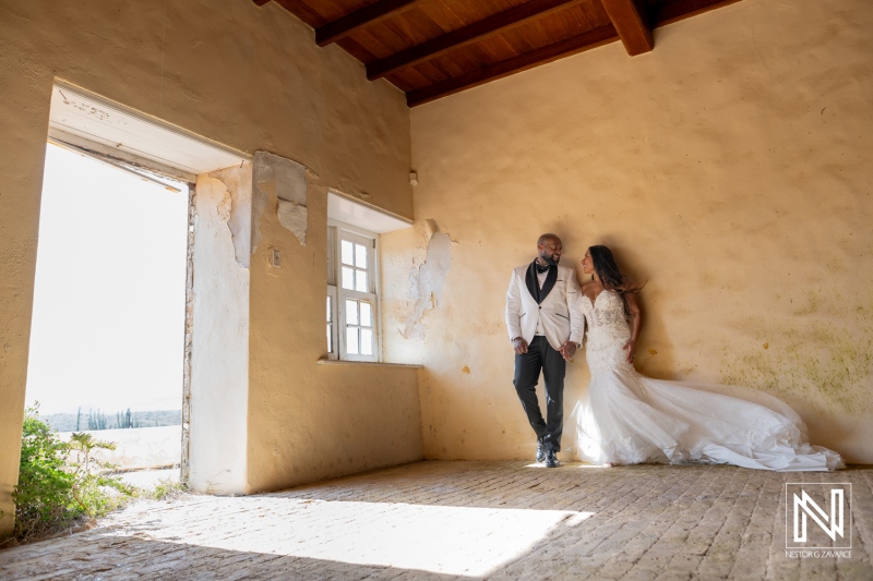 Trash the dress photoshoot takes place in Curacao as couple poses together in old building