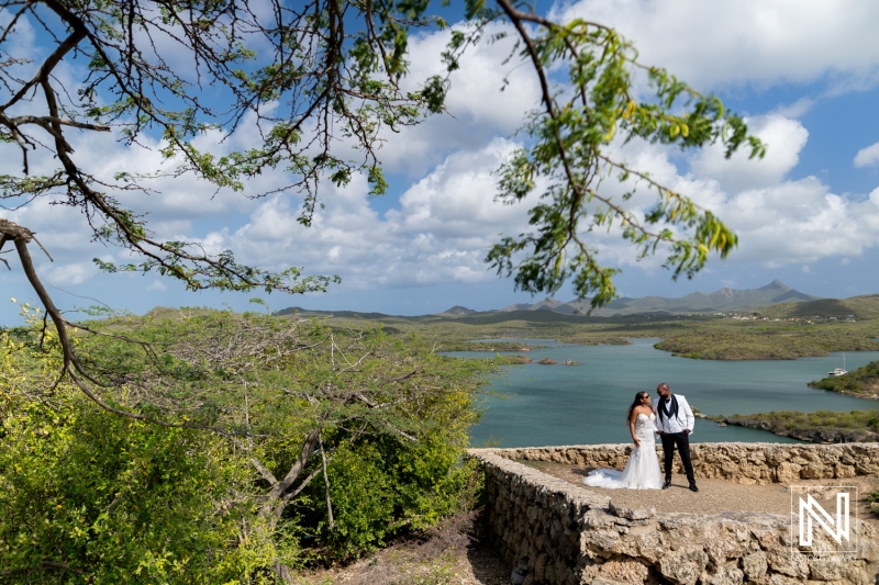 Trash the dress photoshoot in Curacao by the water with couple in wedding attire