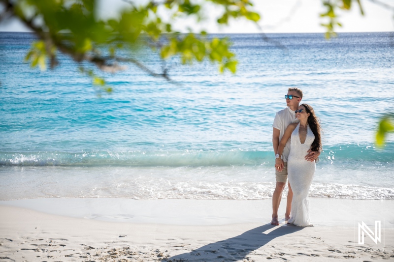 Couple enjoys a trash the dress photoshoot at Cas Abao Beach in Curacao under bright sunlight and clear waters