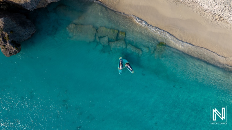 Trash the dress photoshoot takes place at Cas Abao Beach in Curacao during bright daylight by the ocean