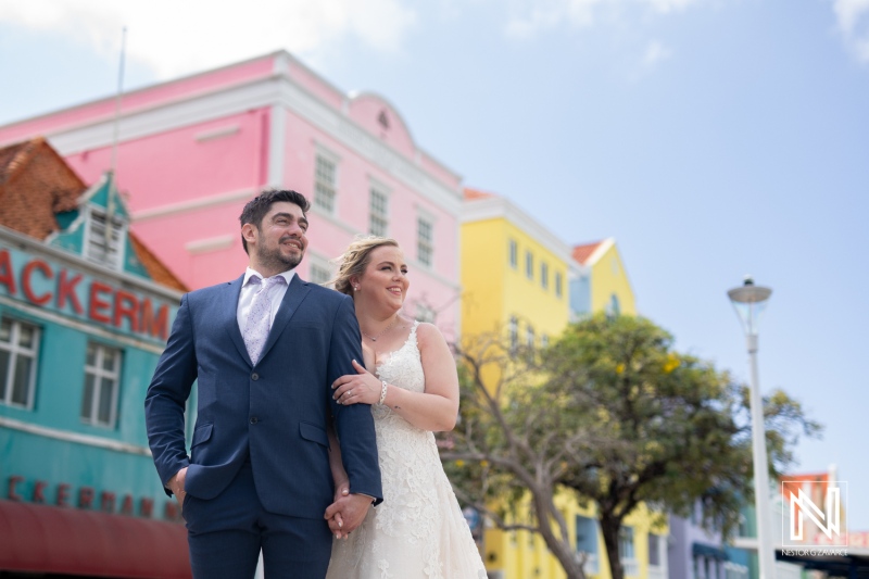 Couples enjoy a Trash the Dress session against the vibrant backdrop of Curacao's colorful buildings with a joyful spirit