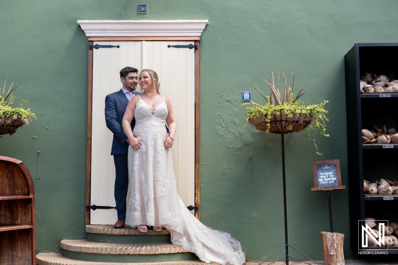 Couple celebrates love in Curacao during Trash the Dress session with vibrant colors and charming backdrop