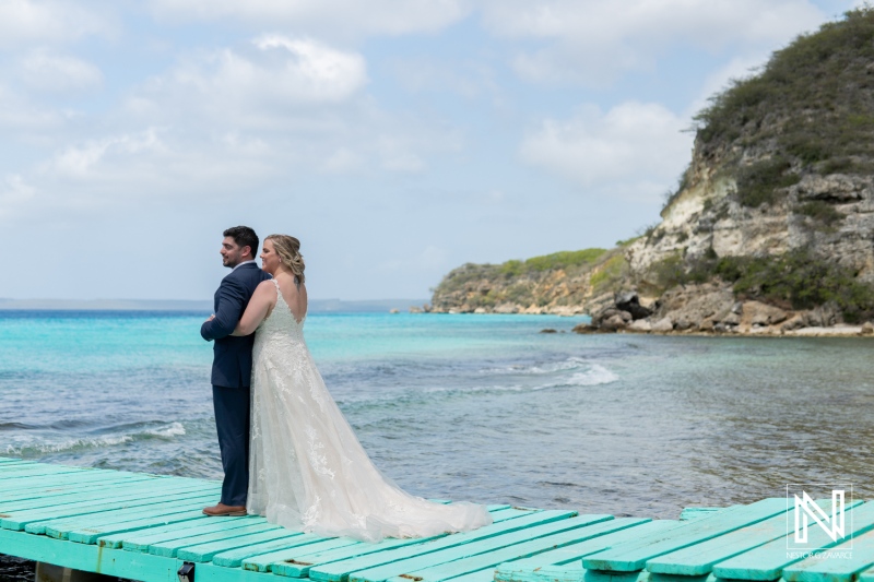 Couple enjoying a romantic trash the dress session on a vibrant turquoise beach in Curacao surrounded by nature's beauty and calm waters