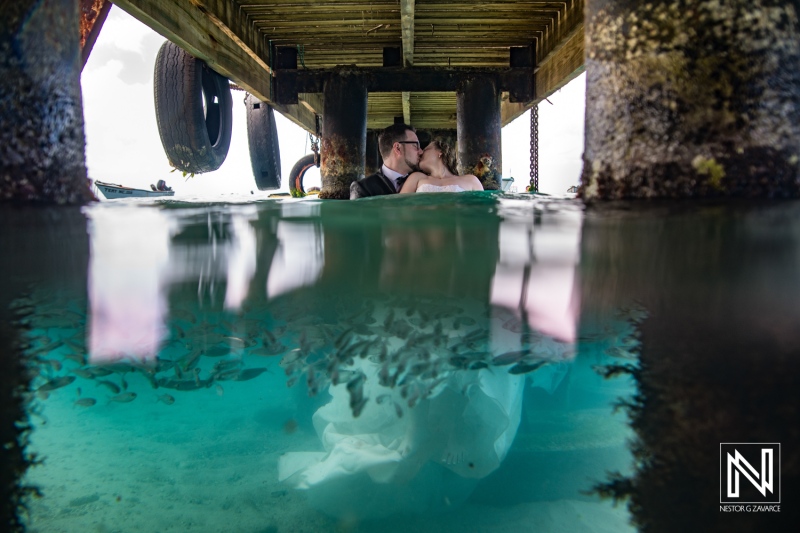 Underwater moment captured in Curacao with couple enjoying time beneath a pier