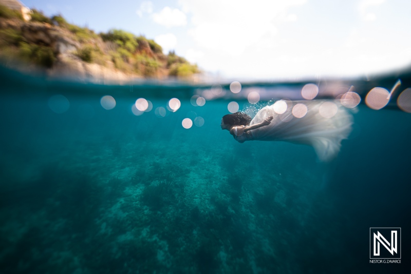 Underwater activity in Curacao with a person wearing a white dress swimming in clear water