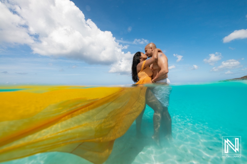 Couple embraces in shallow water during underwater photography session in Curacao