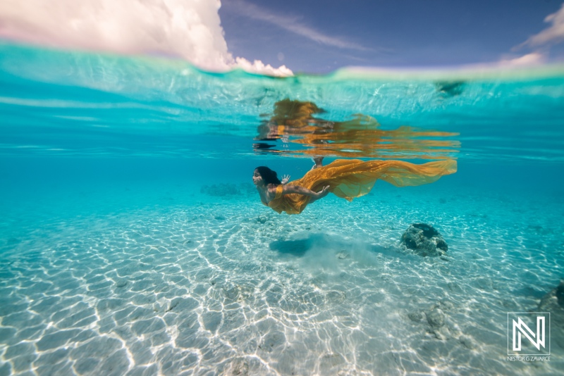 Underwater scene showing a person swimming in clear water with bright sunlight in Curacao